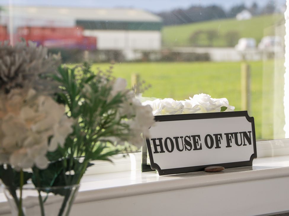 A sign that says HOUSE OF FUN next to flowers at Marchdyke Farm Cottage Dalton near Annan