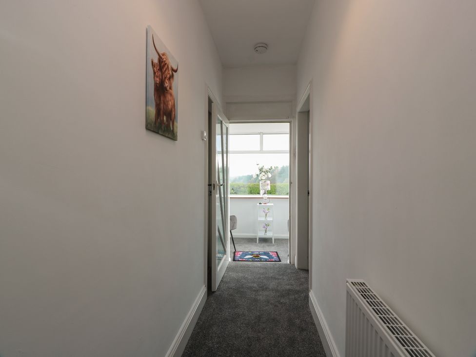 A hallway with a painting and a shelf at Marchdyke Farm Cottage in Dalton near Annan