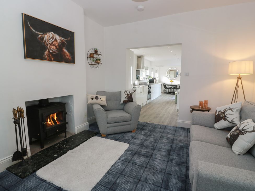 A living room with a fireplace and armchair at Marchdyke Farm Cottage Dalton near Annan