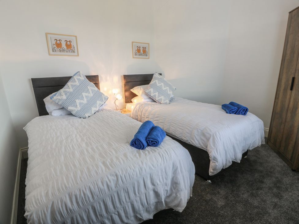 A bedroom with two twin beds and a wardrobe at Marchdyke Farm Cottage in Dalton near Annan