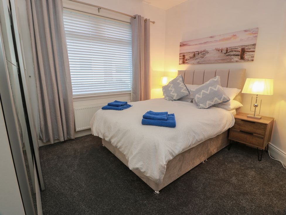 A bedroom with a bed and bedside table at Marchdyke Farm Cottage in Dalton near Annan