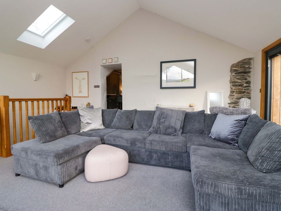 A living room with a grey sofa and footstool at Two Hollens in Ambleside