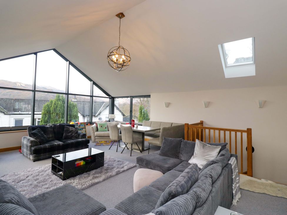 A living room with couches and a dining area at Two Hollens in Ambleside