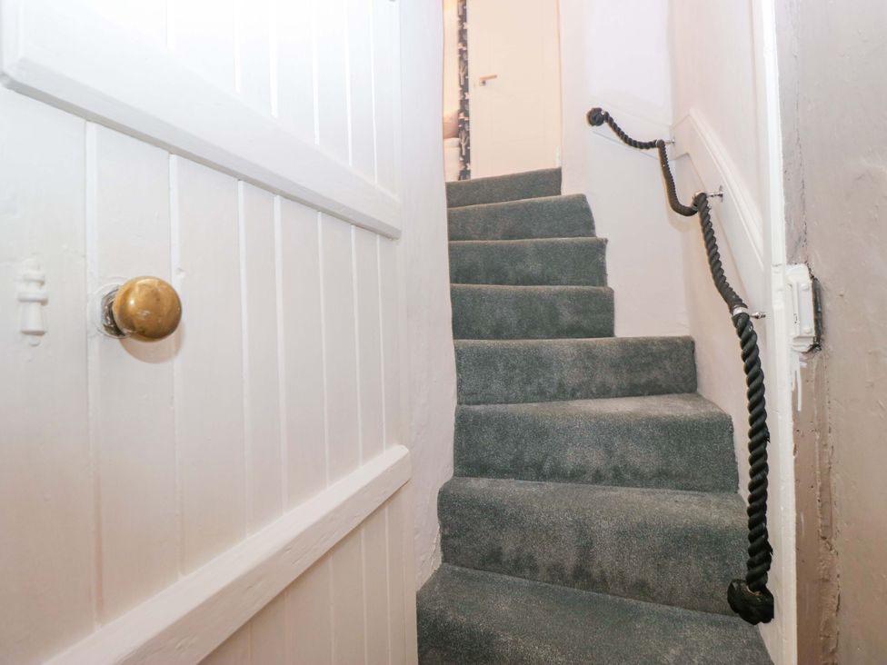 A staircase with carpet and a door at Two Hollens in Ambleside