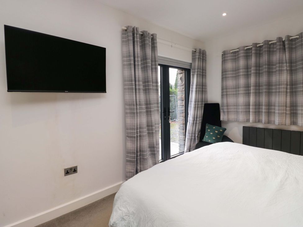 A bedroom with a television and a bed at Two Hollens in Ambleside