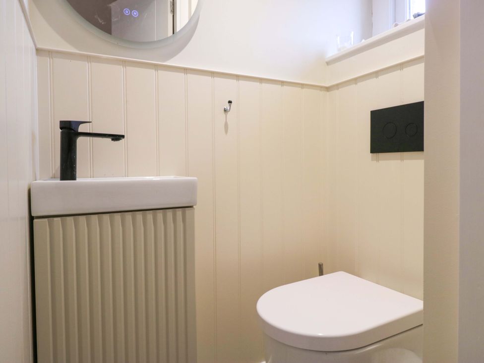 A bathroom with a wash basin and toilet at Two Hollens in Ambleside