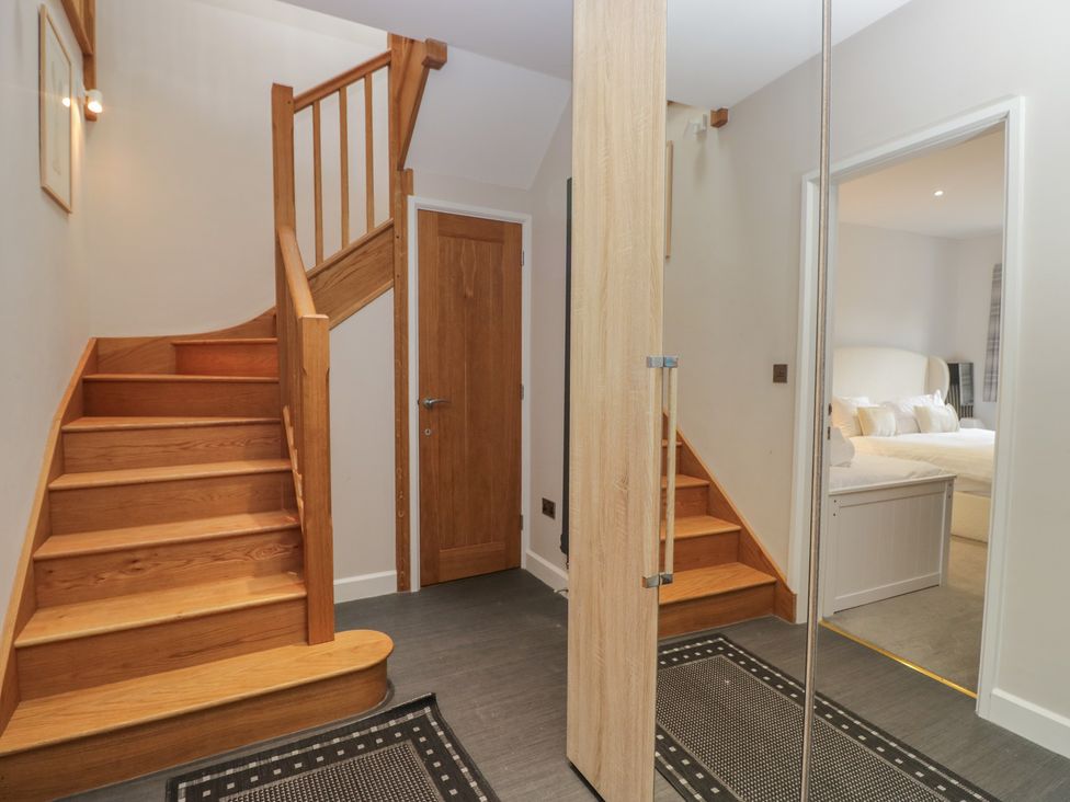 A hallway with staircase and door at Two Hollens in Grasmere