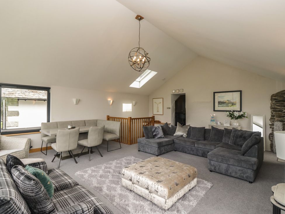 A living room with a sofa and dining area at Two Hollens in Grasmere
