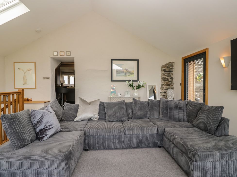 A living room with a sofa and artwork at Two Hollens in Grasmere