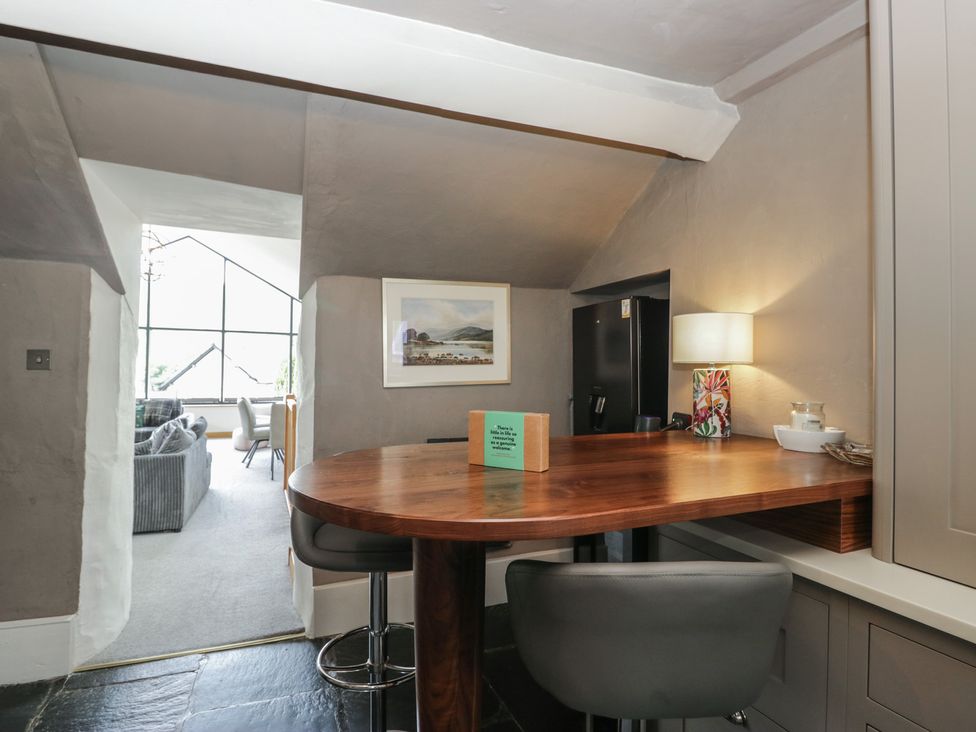 A kitchen with a bar table and stools at Two Hollens in Grasmere