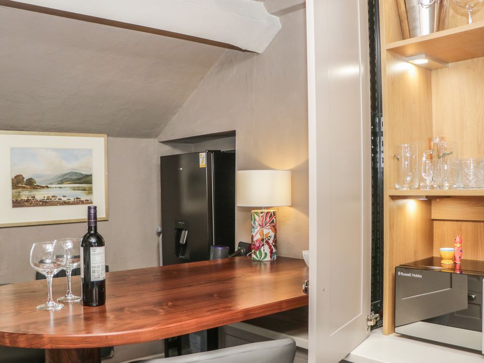 A kitchen with a table and wine on it at Two Hollens in Grasmere