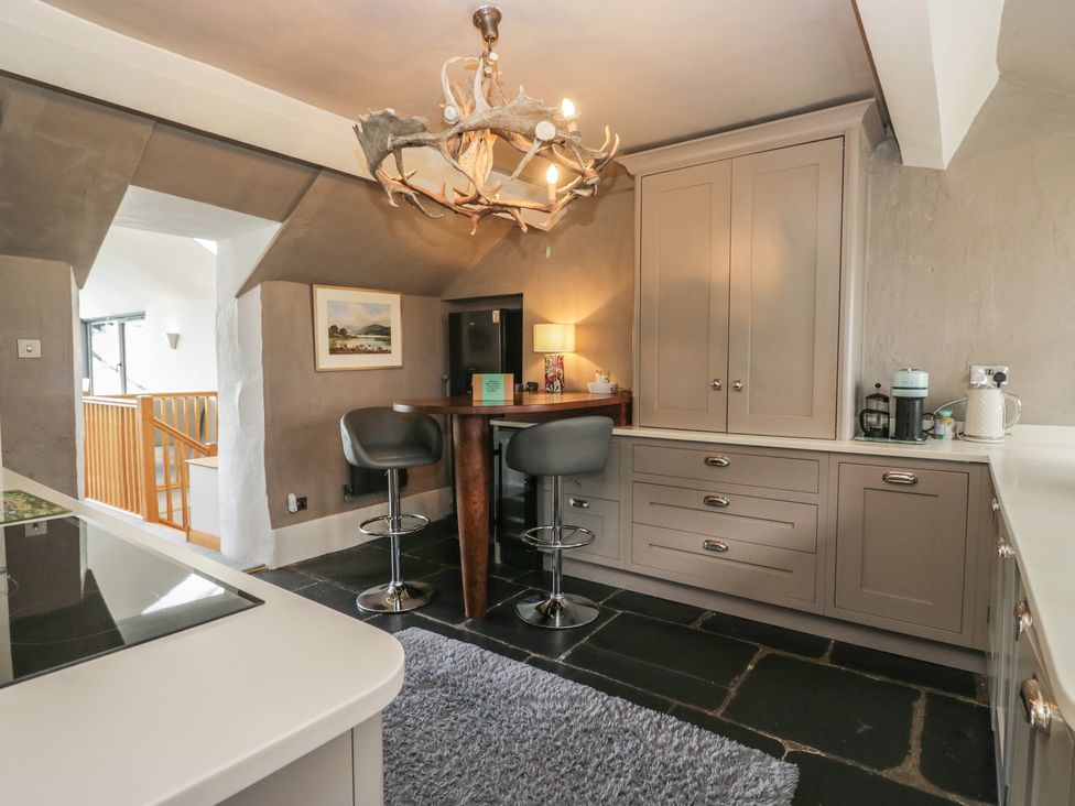 A kitchen with bar stools and cabinets at Two Hollens in Grasmere