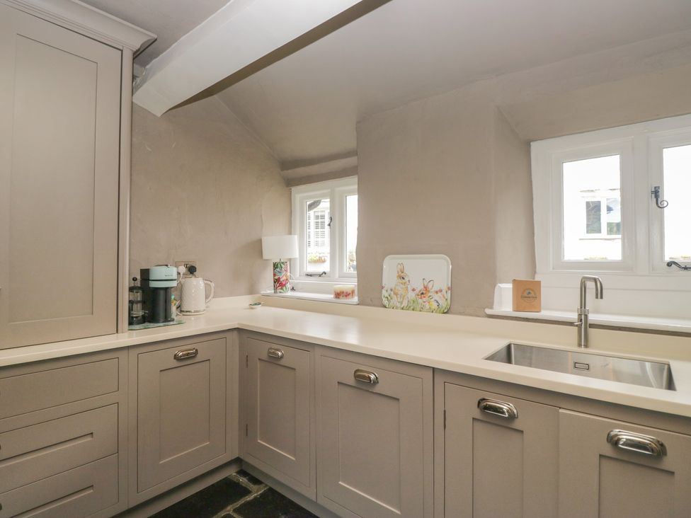 A kitchen with cabinets and sink at Two Hollens in Grasmere