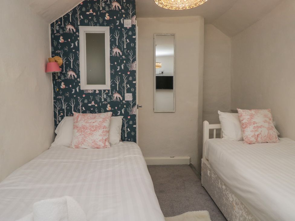 A bedroom with two beds and a mirror at Two Hollens in Grasmere