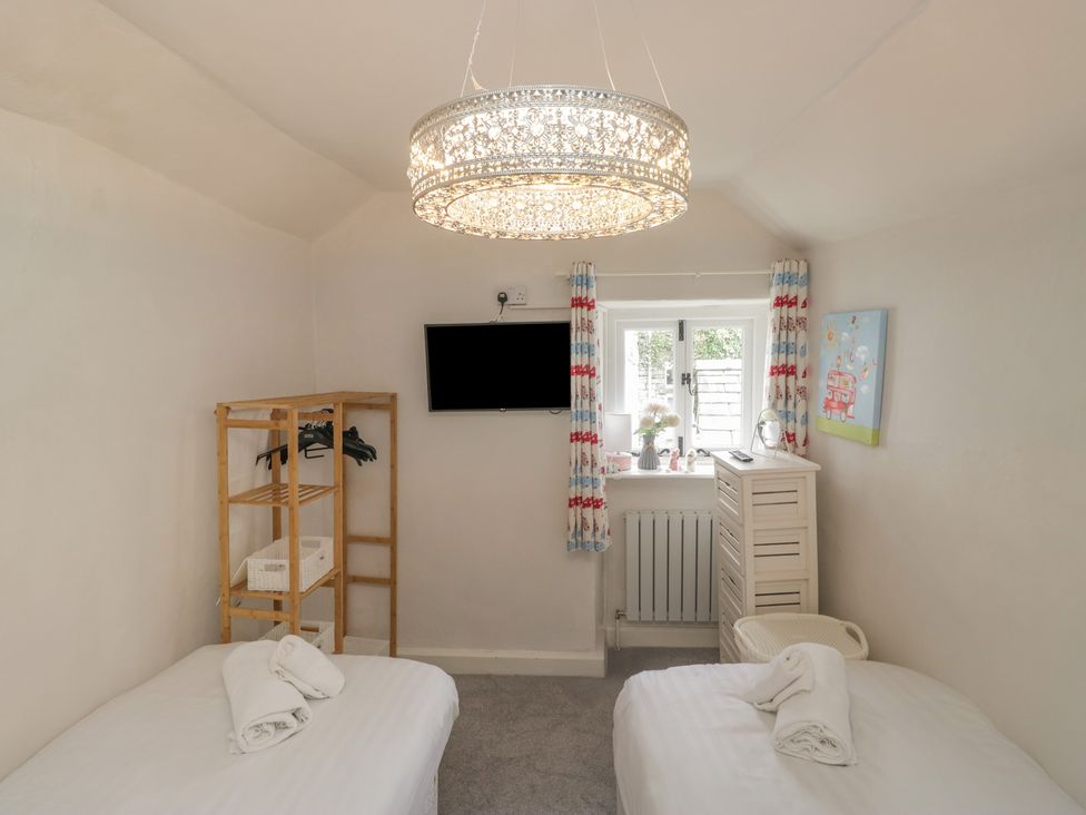 A bedroom with two beds and a television at Two Hollens in Grasmere