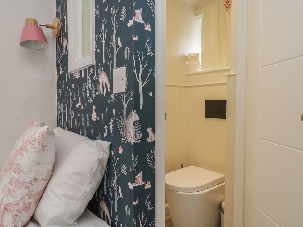 A bathroom with a toilet visible and wallpaper at Two Hollens in Grasmere