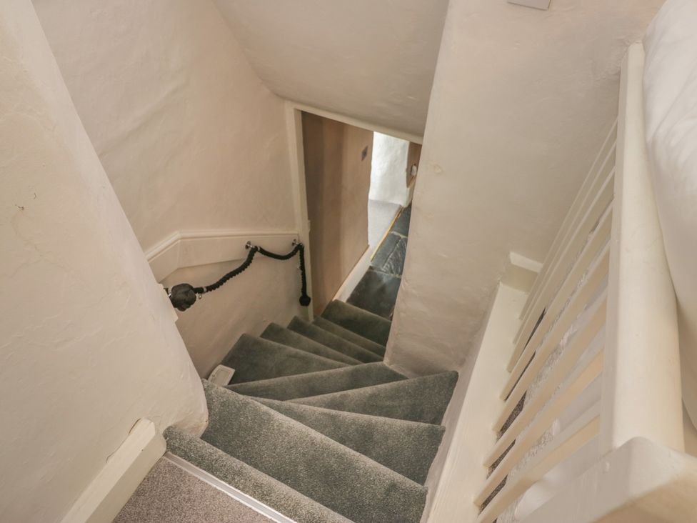 A staircase with carpet and handrail at Two Hollens in Grasmere
