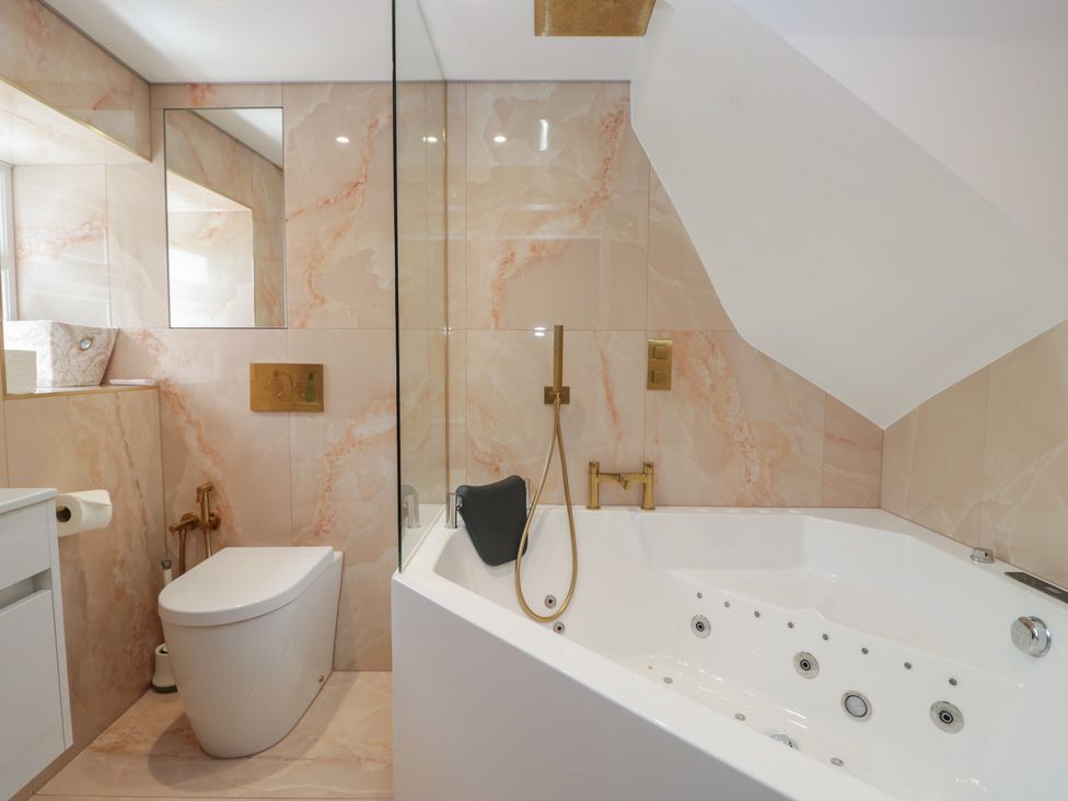 A bathroom with bathtub and toilet at Two Hollens in Grasmere