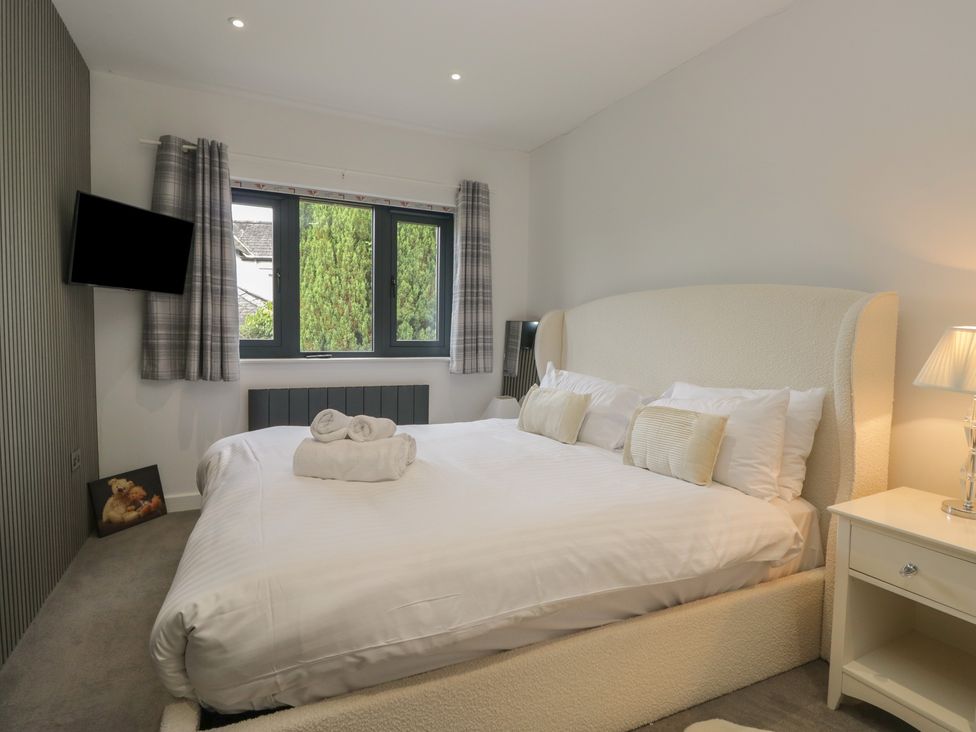 A bedroom with a bed and television at Two Hollens in Grasmere
