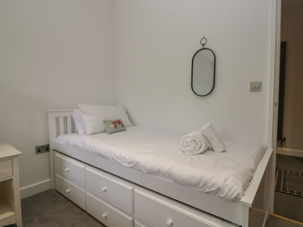 A bedroom with a single bed and storage drawers at Two Hollens in Grasmere