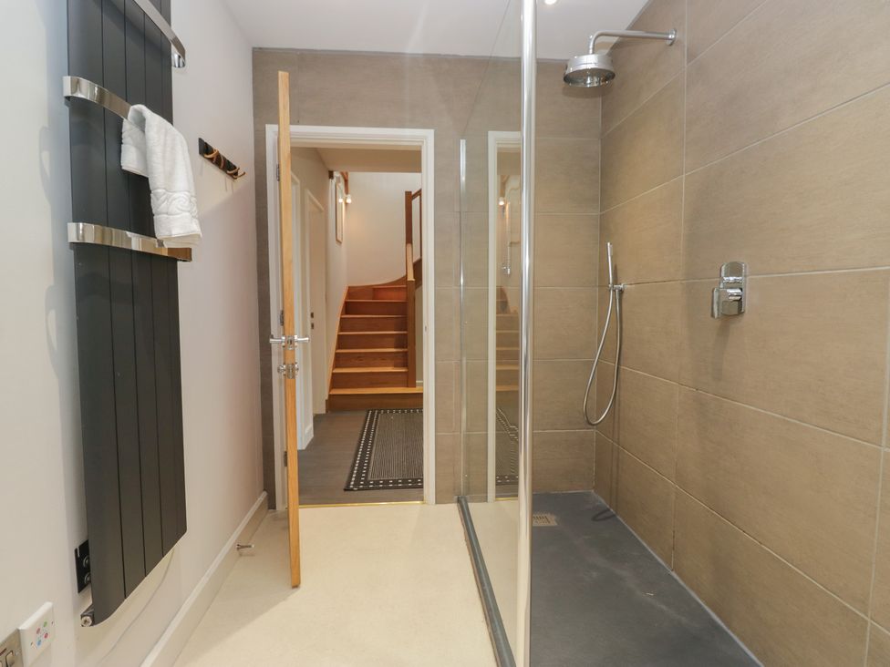 A bathroom with a shower and towel rack at Two Hollens in Grasmere