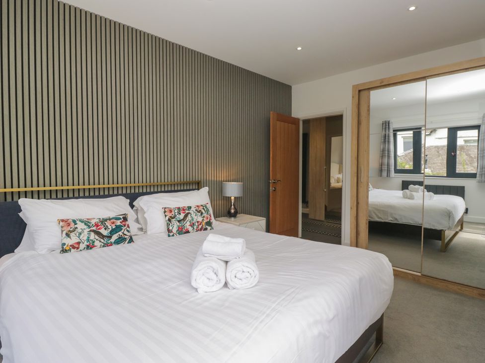 A bedroom with a bed and mirrored wardrobe at Two Hollens in Grasmere