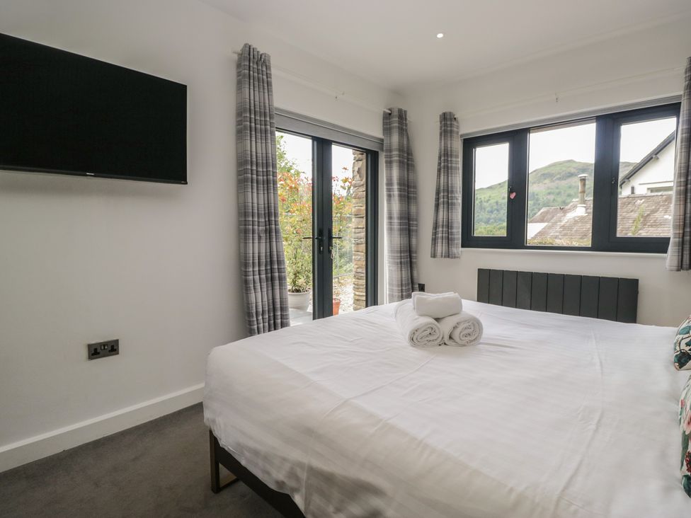 A bedroom with a bed and television at Two Hollens in Grasmere
