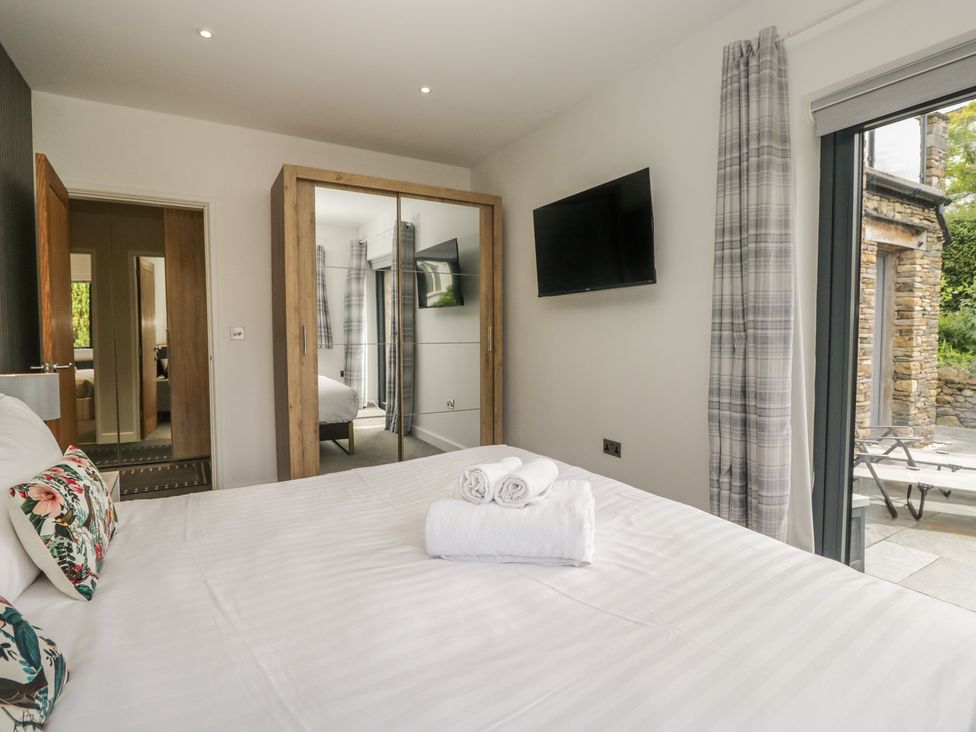 A bedroom with a bed and television at Two Hollens in Grasmere