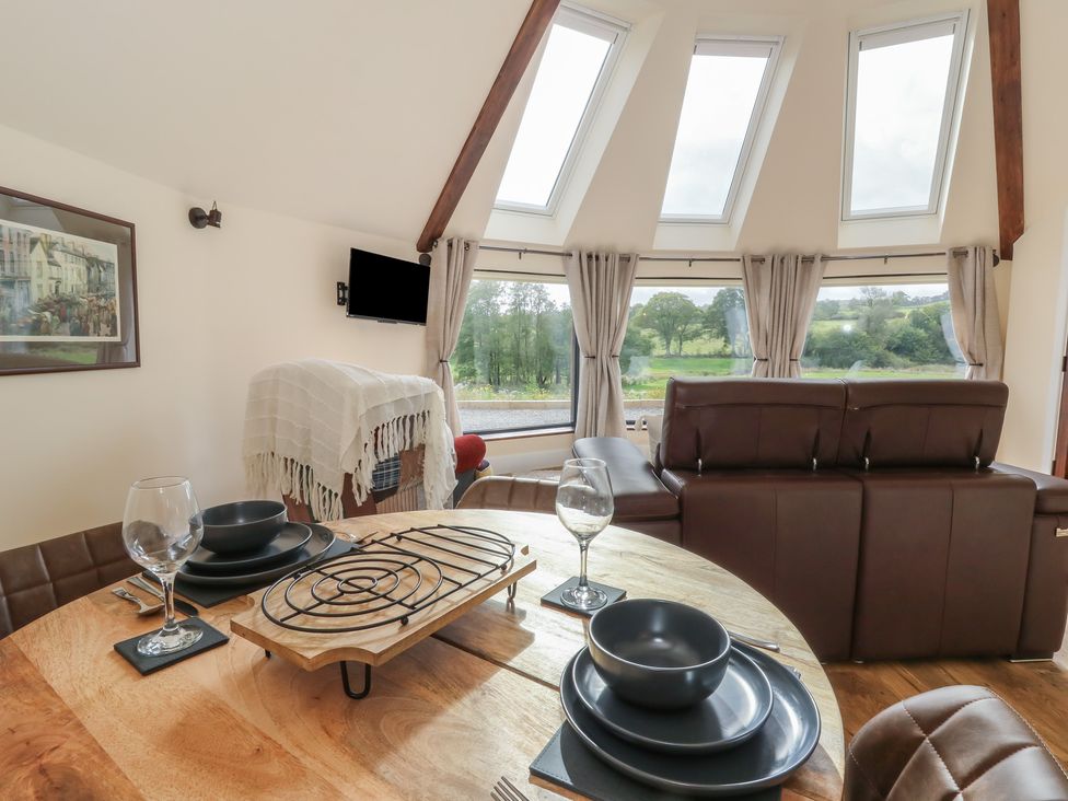 A dining room with a table and chairs at Yr Awen in Lampeter