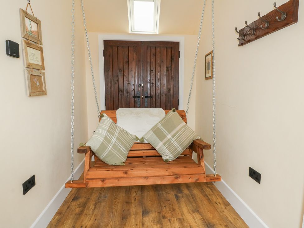A swing with cushions in an indoor area at Yr Awen in Lampeter