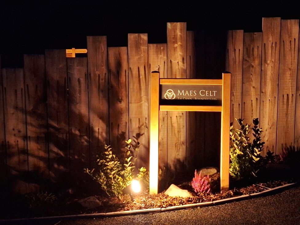 A sign for Maes Celt illuminated at night near Lampeter