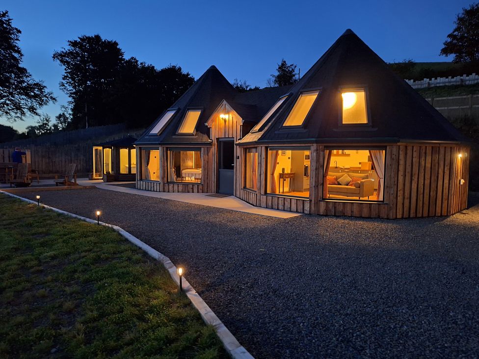 A house with illuminated windows at Y Cwlwm - The Celtic Knot near Lampeter