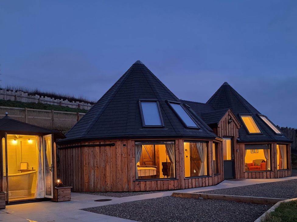 A wooden building with large windows at Y Cwlwm - The Celtic Knot near Lampeter