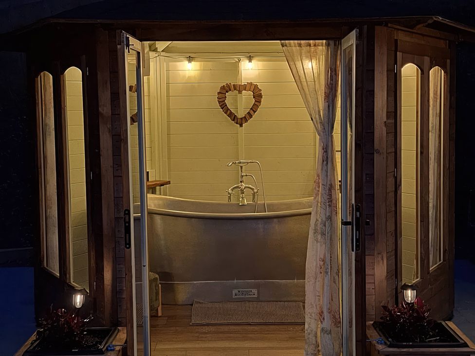 A bathroom with a bathtub and decorative elements at Y Cwlwm - The Celtic Knot near Lampeter