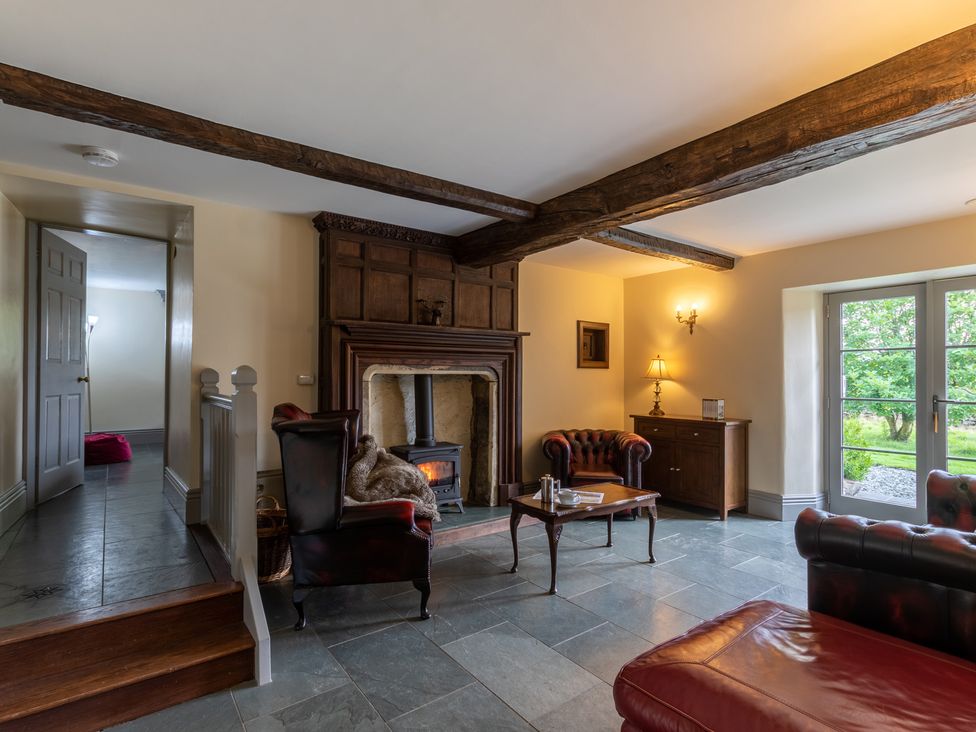 A living room with a fireplace and armchair at Souterstead Torver near Coniston