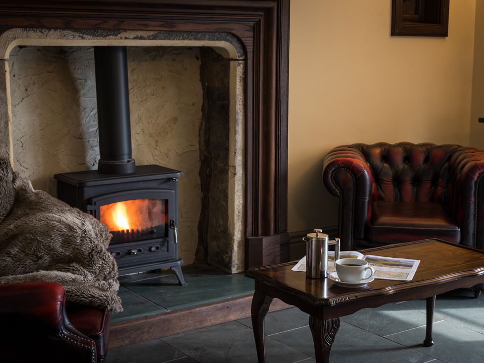 A living room with a fireplace and sofa at Souterstead in Torver near Coniston