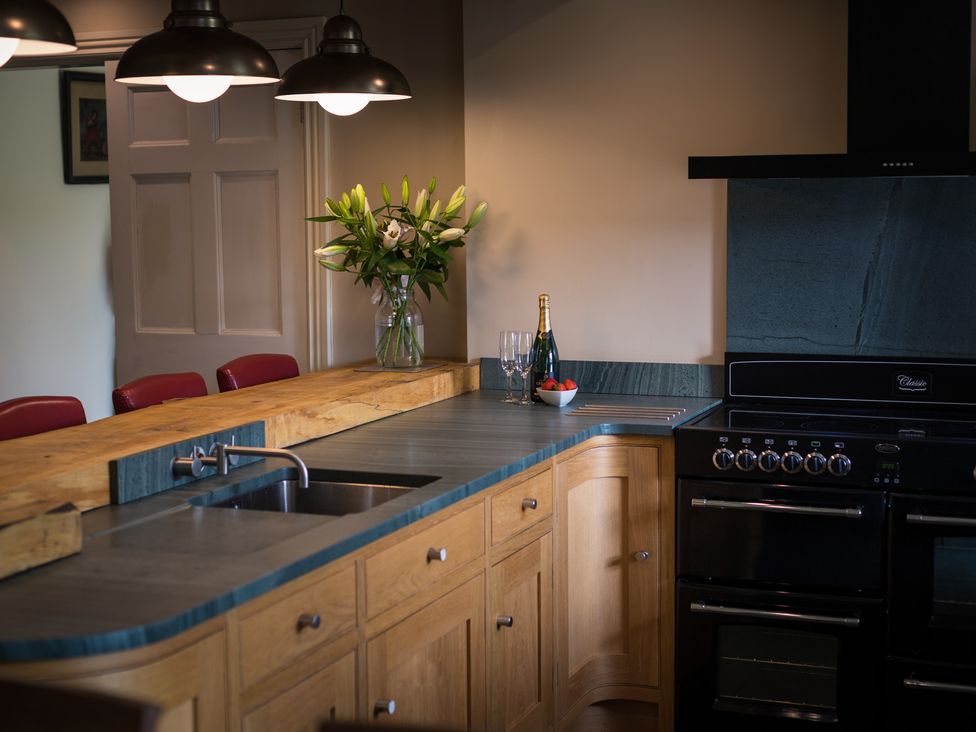 A kitchen with a sink, countertop, oven and a flower vase at Souterstead in Torver near Coniston
