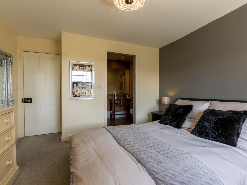 A bedroom featuring a bed, nightstand, and mirror at Souterstead in Torver near Coniston