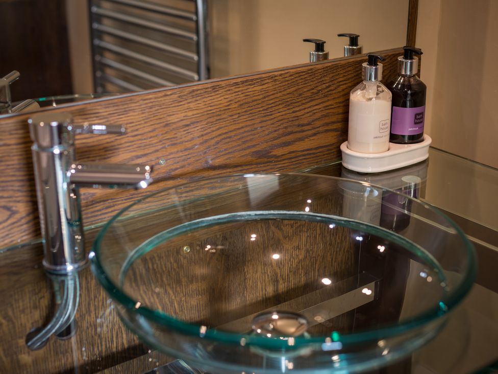A bathroom with a glass sink and soap dispensers at Souterstead in Torver near Coniston