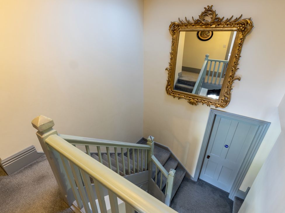 A staircase with a mirror and a door at Souterstead in Torver near Coniston
