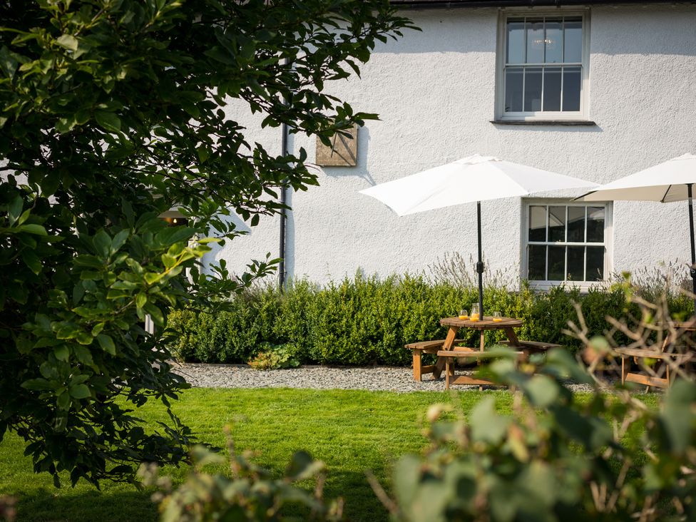 A garden with picnic table and umbrellas at Souterstead in Torver near Coniston