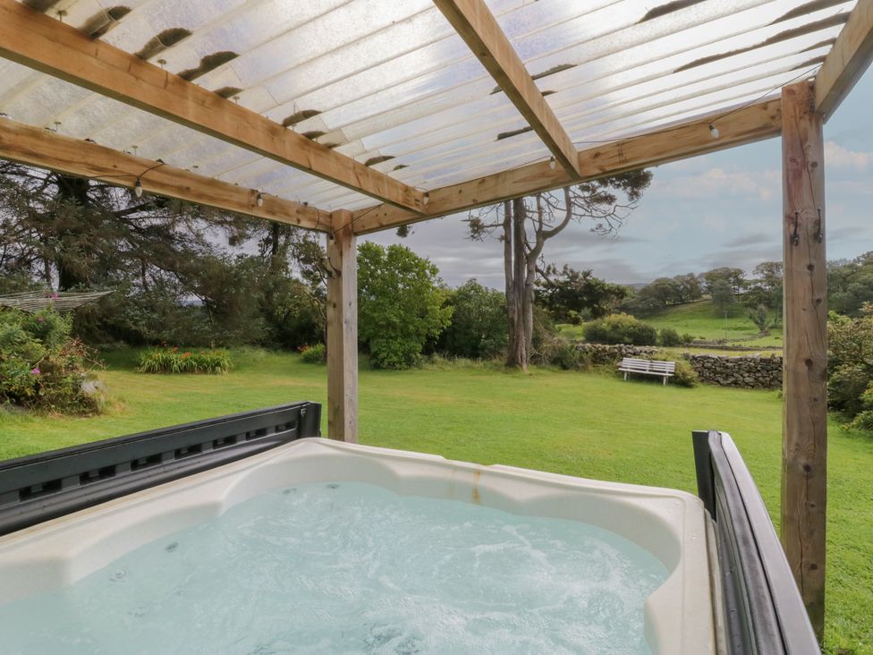 A hot tub under a wooden structure in an outdoor area at Souterstead in Torver near Coniston