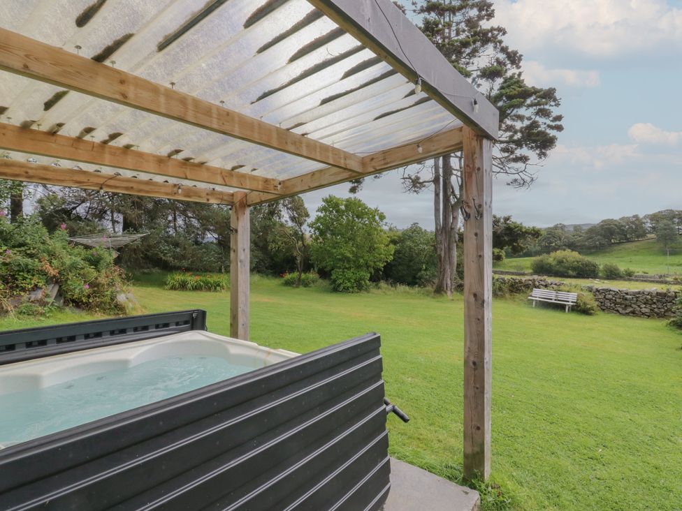 A hot tub under a wooden pergola in a garden at Souterstead Torver near Coniston