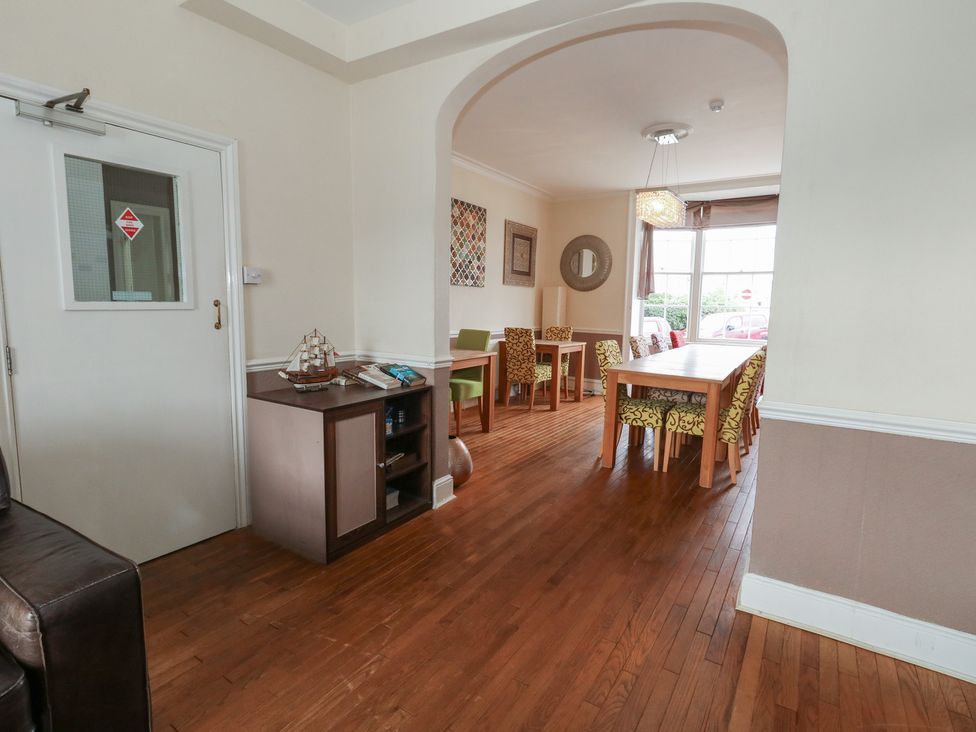 A dining room with a long table and chairs at 9 The Esplanade