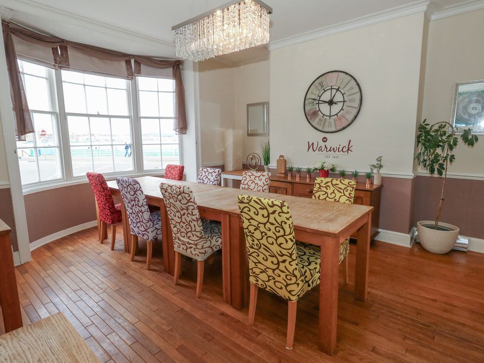 A dining room with a large table and colorful chairs at 9 The Esplanade 