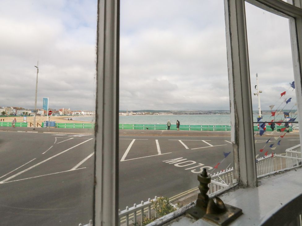 View from a window overlooking the sea and beach at 9 The Esplanade