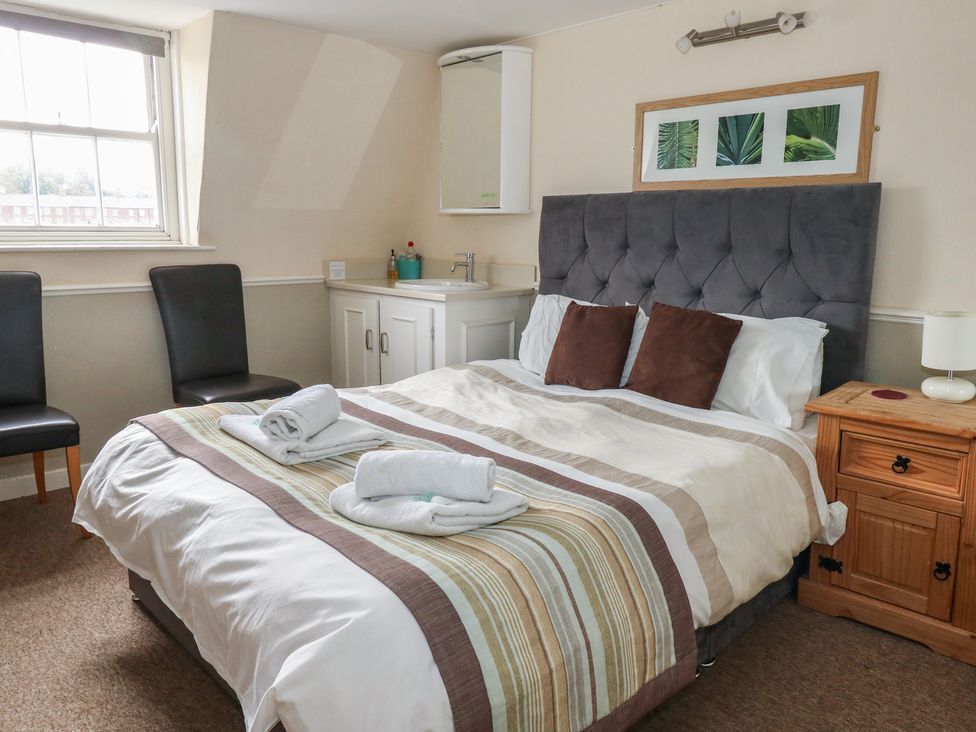 A bedroom with a bed and chairs at 9 The Esplanade