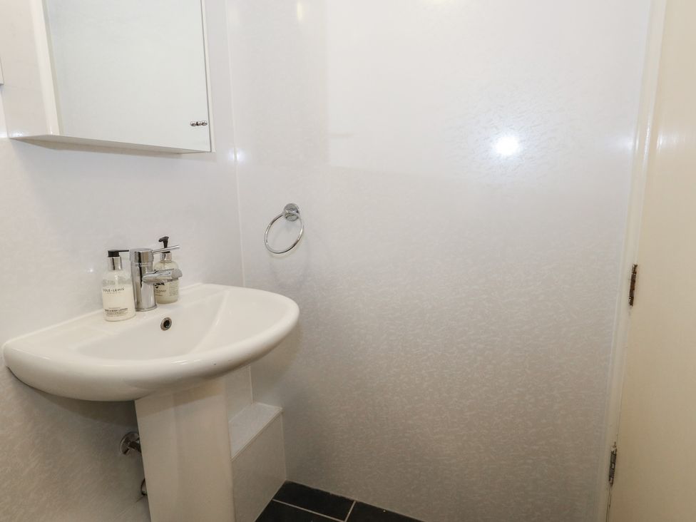 A bathroom with sink and mirror at 9 The Esplanade