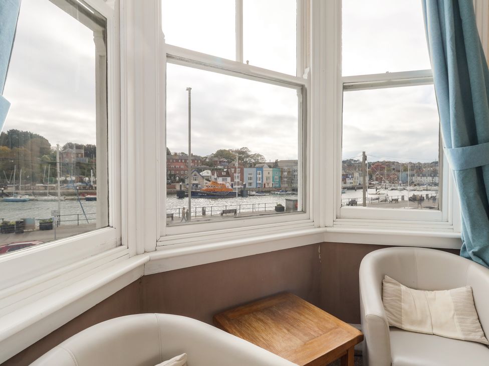 A window view of a harbor with boats and buildings at 9 The Esplanade in 