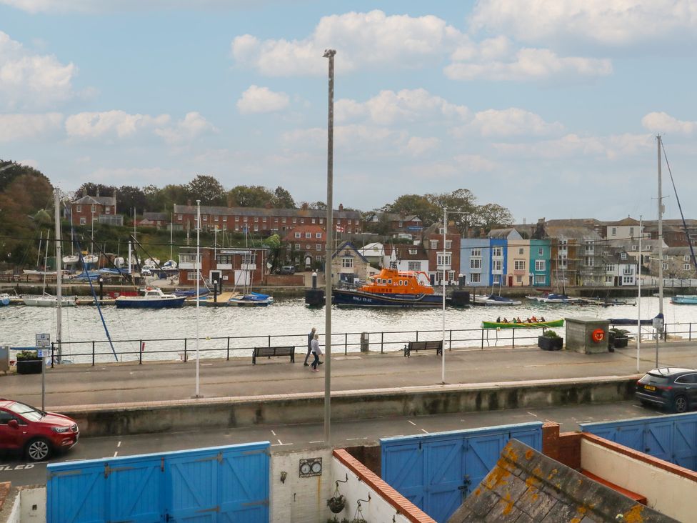 A waterfront scene with boats and buildings at 9 The Esplanade